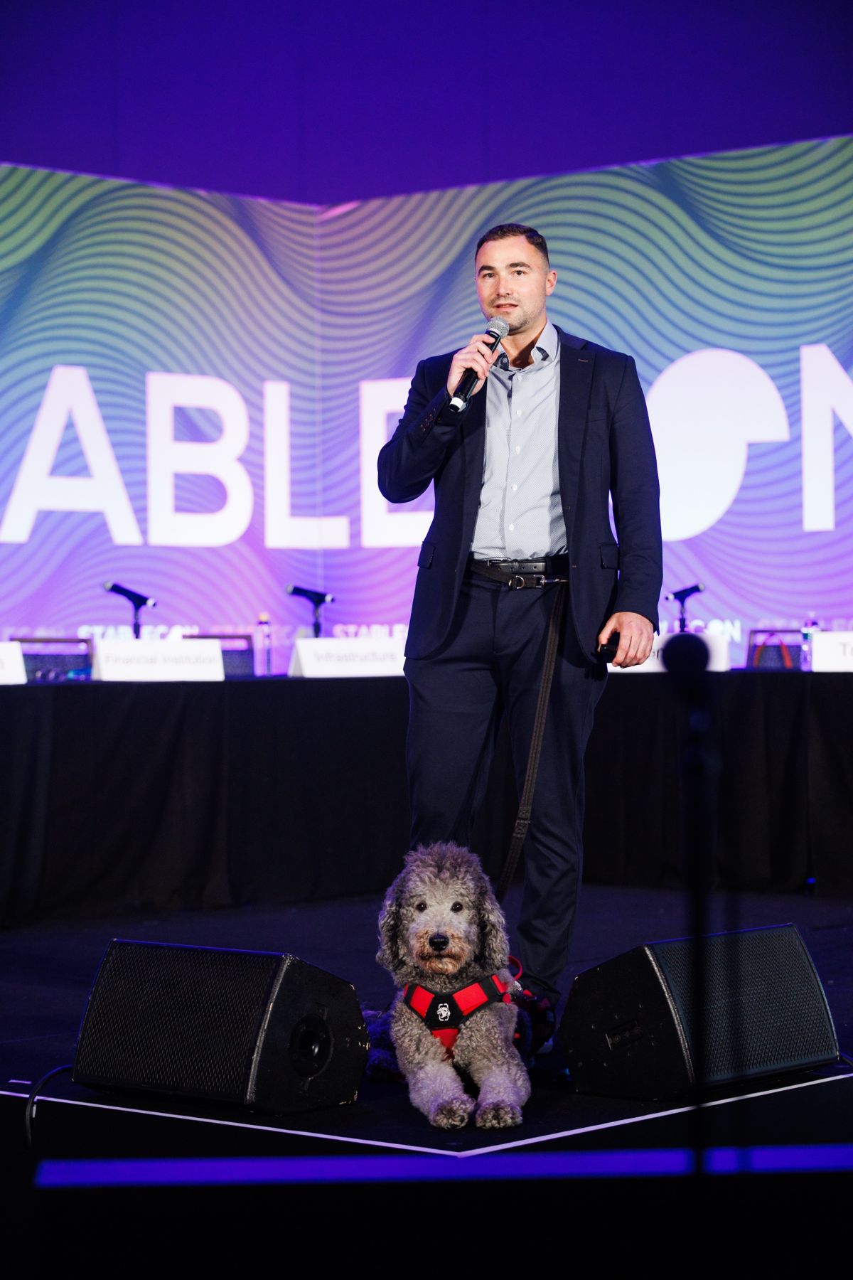 Dominic speaking at StableCon with his service dog Blaze at the front of the stage